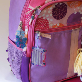 Backpack with Shrinky Dink ID tag and shrink plastic zipper pulls